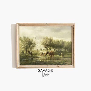 Puede incluir: Una pintura de paisaje enmarcada que presenta dos vacas de pie en una masa de agua poco profunda. La obra de arte representa una escena pastoral con árboles, un cielo nublado y figuras en la distancia. El marco es de madera clara.