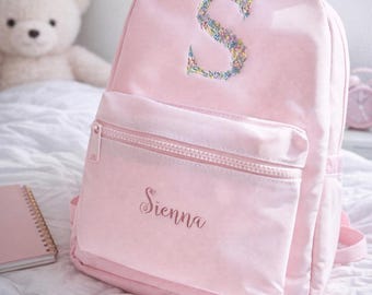 Mochila infantil personalizada con monograma floral bordado.