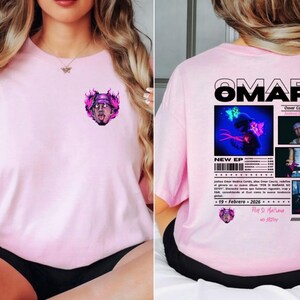 May include: A light pink t-shirt featuring a graphic of a person with flames and the text "Omar Courtz". The back of the shirt displays the name "Omar Courtz", "New EP", and other text with images.
