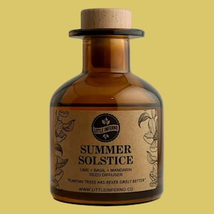 May include: A brown glass bottle with a light wood stopper. The label features the text Little Inferno, Summer Solstice, Lime + Basil + Mandarin Reed Diffuser, Planting trees has never smelt better, and www.littleinferno.co with floral illustrations.
