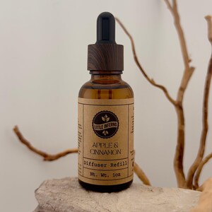 May include: A white ceramic mug with a black handle and the text "But First, Coffee" in a black, handwritten-style font. The mug is on a white surface.