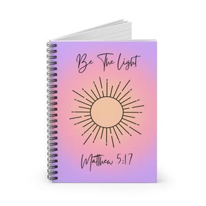 Op de afbeelding: Een spiraalnotitieblok met een paars-roze gradiënt, een zonafbeelding en de tekst "Be the Light" en "Matthew 5:17".