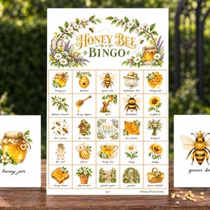 May include: A Honey Bee Bingo game set featuring a large central card with twenty-five illustrated squares, including a bee, hive, and flowers. Two smaller cards are displayed on the sides, one showing a honey jar and the other a queen bee.