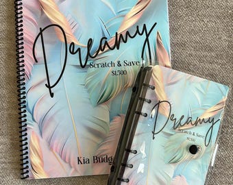 May include: Two spiral bound notebooks with a tropical leaf design. The covers are clear plastic with a printed design underneath. The text on the covers reads "Dreamy Scratch & Save $1300" and "Kia Budgets".