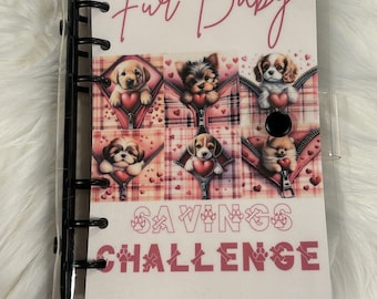 May include: A clear plastic binder with a pink and white cover featuring a collage of cute puppies with hearts and the text "Fur Baby Savings Challenge" and "KIA Budgets".