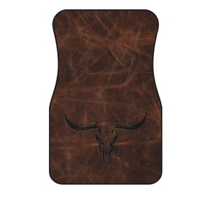 May include: Brown leather car floor mat with a black embossed bull skull design.