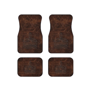 May include: A set of four dark brown car floor mats featuring a distressed leather-like texture and a centred, embossed linear crown design. The collection includes two larger rectangular mats with rounded top corners and two smaller rectangular mats.
