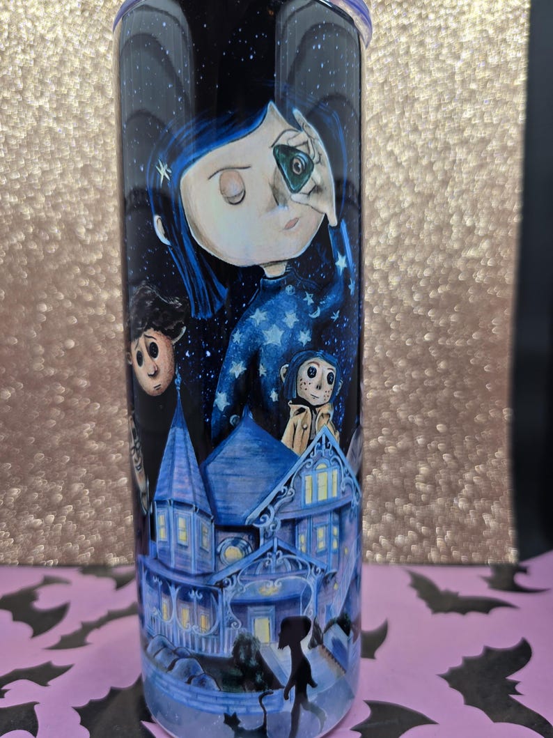 Pode incluir: Um copo alto e cil&iacute;ndrico com uma ilustra&ccedil;&atilde;o detalhada do filme de anima&ccedil;&atilde;o Coraline. O design inclui personagens, uma casa azul e um c&eacute;u estrelado. O copo &eacute; principalmente azul escuro com uma tampa roxa.