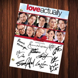 Könnte beinhalten: Eine weiße Karte mit dem Titel "loveactually" in schwarzer Schrift. Die Karte zeigt eine Collage von Fotos der Besetzung aus dem Film. Die Karte ist von der Besetzung und dem Regisseur Richard Curtis signiert.