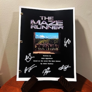 May include: A black and white script for the movie "The Maze Runner" with a photo of the cast and several autographs. The script is written by Noah Oppenheim and based on the novel by James Dashner.