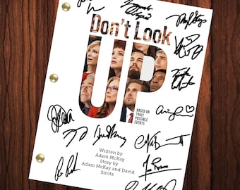 May include: A black and white script for the movie "Don't Look Up" with the title and the words "Based on Truly Possible Events" and "Written by Adam McKay, Story by Adam McKay and David Sirota". The script is signed by the cast and crew, including Leonardo DiCaprio, Jennifer Lawrence, Meryl Streep, Cate Blanchett, Tyler Perry, Timothée Chalamet, Ariana Grande, and others.