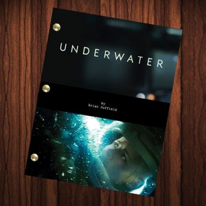 Può includere: Una copertina di sceneggiatura di un film in bianco e nero con il titolo "UNDERWATER" e il testo "by Brian Duffield". La copertina presenta un primo piano del viso di una donna in una muta da subacquea sott'acqua.