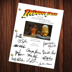 Może przedstawiać: Czarno-białe zdjęcie podpisanego scenariusza filmu Indiana Jones i Poszukiwacze Zaginionej Arki. Scenariusz jest podpisany przez Harrisona Forda, George'a Lucasa, Lawrence'a Kasdana i innych.