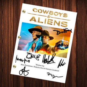 May include: A white script page with the title "COWBOYS & ALIENS" in gold lettering. The page features a movie poster with three people, a man in a cowboy hat, a man in a fedora, and a woman. The poster has a blue and orange background with a fiery explosion. The page is signed by several people, including "Drew Goddard", "Alex Kurtzman", "Roberto Orci", and "Damon Lindelof".