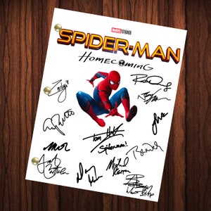 Può includere: Un foglio di carta bianco con il titolo "Spider-Man Homecoming" in lettere rosse e gialle. Il foglio è firmato dal cast e dalla troupe, tra cui Tom Holland, Zendaya e Michael Keaton.