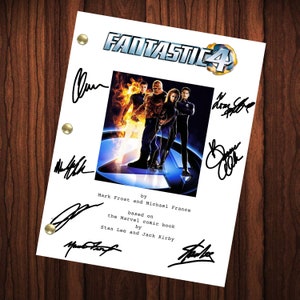 Op de afbeelding: Een wit papier met de titel "Fantastic 4" en een filmposter. Het papier is door meerdere mensen gesigneerd. De tekst "by Mark Frost and Michael France" en "based on the Marvel comic book by Stan Lee and Jack Kirby" is ook zichtbaar.