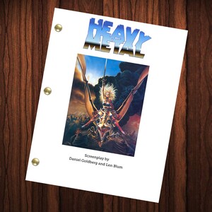 May include: A white sheet with the title "HEAVY METAL" in a chrome-style font. The image below depicts a woman riding a winged creature over a city. The text "Screenplay by Daniel Goldberg and Len Blum" is at the bottom.