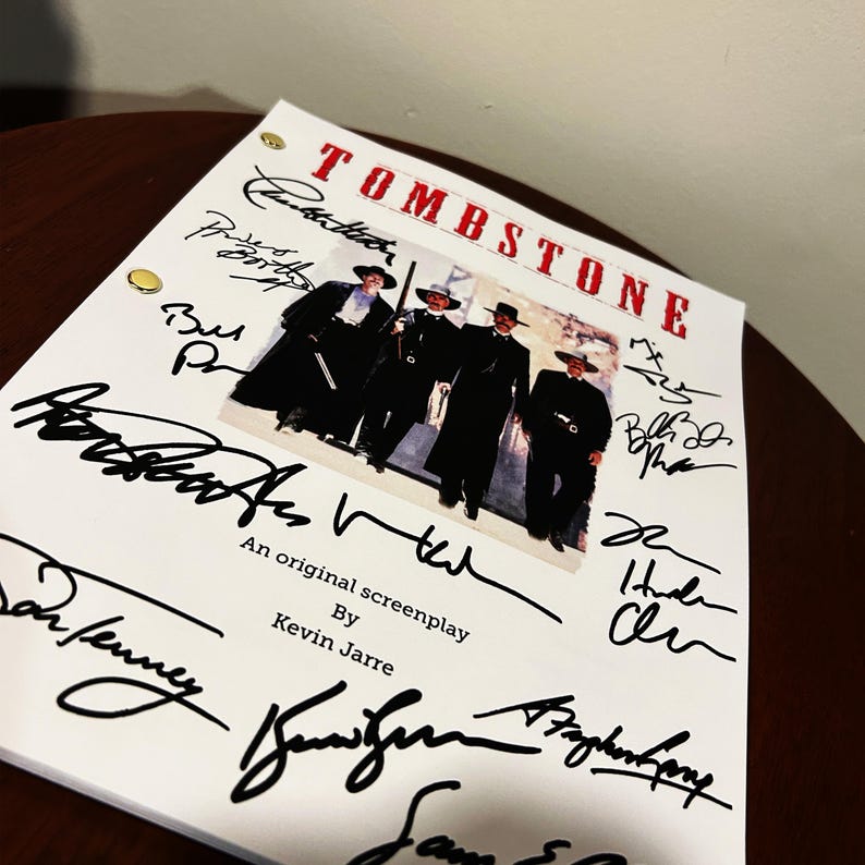 May include: A white script for the movie "Tombstone" with signatures from the cast and crew. The signatures include Kurt Russell, Val Kilmer, Sam Elliott, and others. The script is an original screenplay by Kevin Jarre.