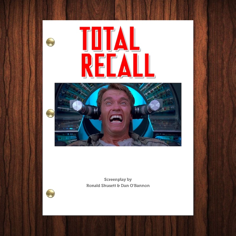 May include: A movie script cover for the film "Total Recall" featuring a close-up of Arnold Schwarzenegger in a futuristic chair with wires attached to his head. The title "Total Recall" is in red letters.