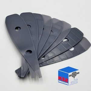 May include: A set of ten grey plastic guitar picks with rounded edges and a hole in the centre. The picks are arranged in a fan shape.