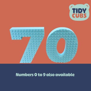 May include: Light blue number 70 made of interlocking toy blocks, set against an orange background. The Tidy Cubs logo is in the upper right corner. Text at the bottom reads "Numbers 0 to 9 also available."