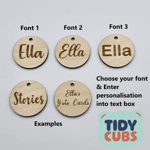May include: Three wooden circles with different fonts for the name "Ella" and two more circles with the text "Stories" and "Ella's Yoto Cards".  The image also includes the text "Choose your font & Enter personalisation into text box" and a logo for "TIDY CUBS".
