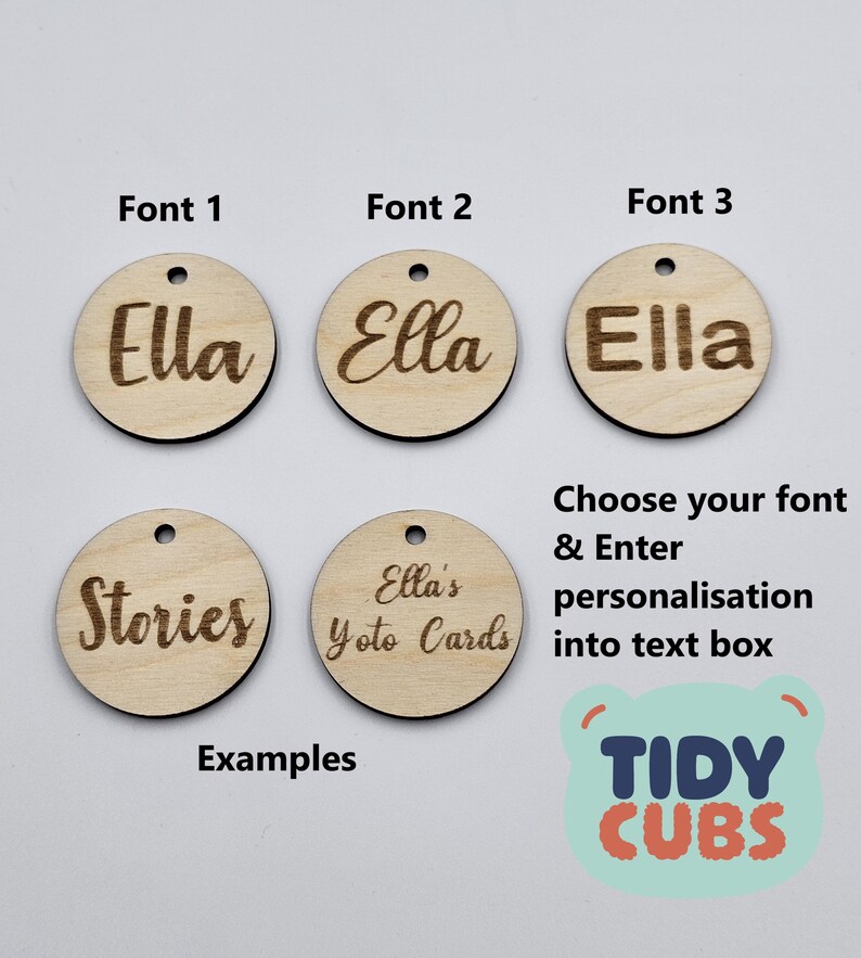 May include: Three wooden circles with different fonts for the name "Ella" and two more circles with the text "Stories" and "Ella's Yoto Cards".  The image also includes the text "Choose your font & Enter personalisation into text box" and a logo for "TIDY CUBS".