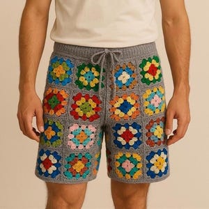 May include: Gray crochet shorts with a colorful granny square pattern. The shorts have a drawstring waist.