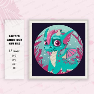 May include: A layered cardstock cut file design featuring a cute, teal and pink dragon with large eyes. The dragon is standing on a pink and teal background with a snowy, wintery feel.