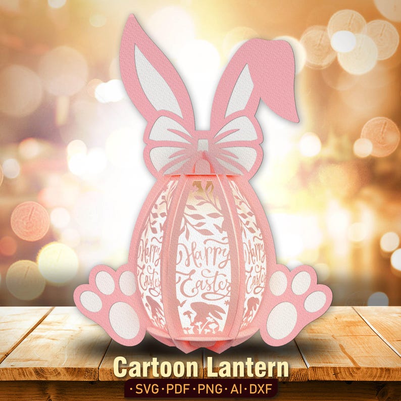 Pu&ograve; includere: Lanterna di Pasqua a forma di coniglio rosa con un fiocco bianco e le parole "Buona Pasqua" sul davanti.