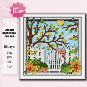 May include: A layered cardstock cut file featuring a sunny outdoor scene. The artwork includes a white picket fence, a tree with yellow flowers, a sun, and a beach chair with a pink hat. The image is framed in white and includes the text "Free Frame".