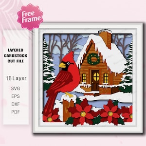 May include: A layered cardstock cut file featuring a vibrant red cardinal perched on a fence, with a snow-covered cabin in the background. The image includes poinsettias and text that reads "Free Frame" and "16 Layer SVG EPS DXF PDF".