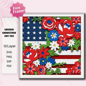 May include: A layered cardstock cut file featuring a patriotic design. The artwork showcases the American flag with red and white stripes, a blue field of stars, and colorful floral accents. The design includes the text "Free Frame" and "Layered Cardstock Cut File".