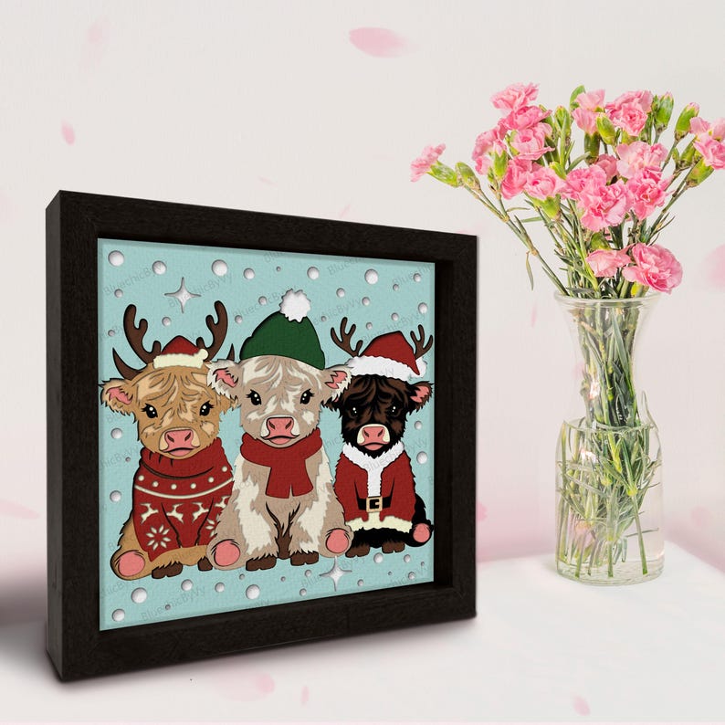 May include: A framed print featuring three Highland cows dressed in Christmas attire. The cows are wearing Santa hats, sweaters, and scarves, set against a light blue background with snowflakes. The frame is black.