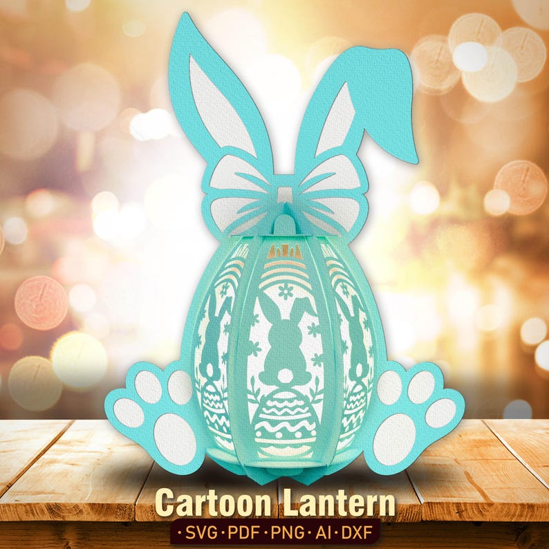 Pu&ograve; includere: Una lanterna di Pasqua a forma di coniglio blu chiaro con un fiocco bianco e un design a uovo bianco. La lanterna ha la forma di un uovo e ha un viso di coniglio bianco sul davanti. La lanterna &egrave; appoggiata su una superficie di legno.