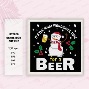 May include: A black and white layered cardstock cut file design featuring a snowman holding a beer with the text "It's the most wonderful time for a beer".