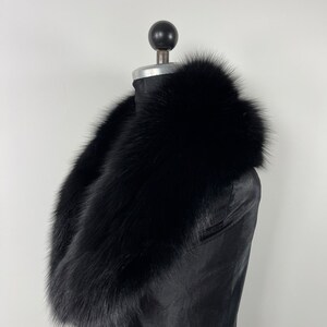 May include: A black fur collar, worn on a black mannequin. The collar is thick and fluffy, with a soft, luxurious texture.