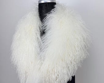 May include: A fluffy, white faux fur collar. The collar is thick and voluminous, with a soft, curly texture. It is displayed on a black mannequin, against a plain gray background. The collar appears to be a luxurious accessory.
