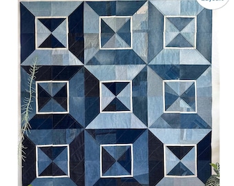 Könnte beinhalten: Eine Jeans-Steppdecke mit einem geometrischen Muster aus Quadraten und Dreiecken. Die Steppdecke ist aus verschiedenen Blautönen von Jeans gefertigt und hat weiße Nähte an den Rändern. Die Steppdecke ist 69 Zoll mal 69 Zoll groß.