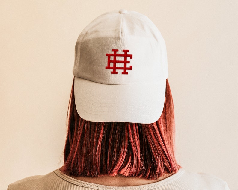May include: A white baseball cap with a red embroidered hashtag symbol on the front.