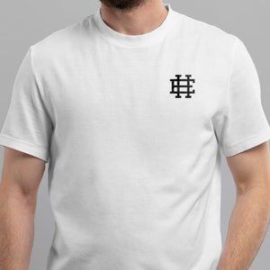 May include: White t-shirt with a black embroidered logo of a grid pattern with the letter "H" in the center.