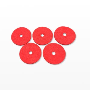 May include: Five red felt circles with a small hole in the center, arranged on a white background. The circles are evenly spaced and appear to be made of a soft, textured material. The color is a vibrant, solid red.