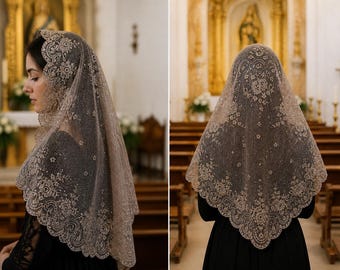 Könnte beinhalten: Eine beige Spitzenmantilla, eine traditionelle Kopfbedeckung, ist über den Kopf und die Schultern einer Person drapiert. Die zarte Spitze weist florale Muster und einen gewellten Rand auf. Die Person trägt ein schwarzes Kleid, und der Hintergrund ist ein Kircheninnenraum.