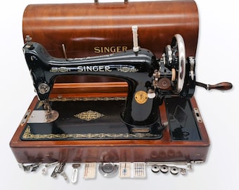 Máquina de coser con manivela marca Singer Año 1927 Modelo 66K con accesorios y guardapolvo de madera