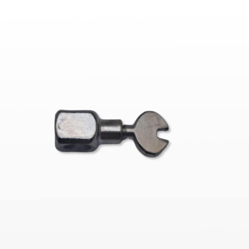May include: A small, metallic wrench with a square head and a crescent-shaped end. The tool is silver-colored and appears to be made of metal. The wrench is designed for tightening or loosening nuts and bolts.