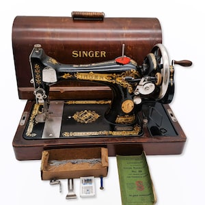 Singer 100 year old hand crank sewing machine, model 28K, with wooden case and some accessories