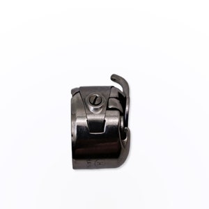 May include: A silver sewing machine foot with a small screw and the text "HA14" on the side.