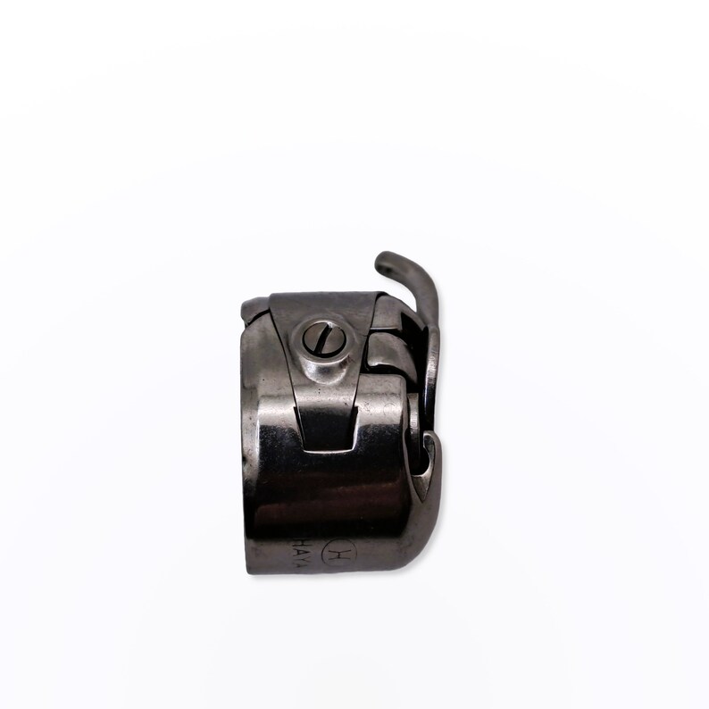May include: A silver sewing machine foot with a small screw and the text "HA14" on the side.