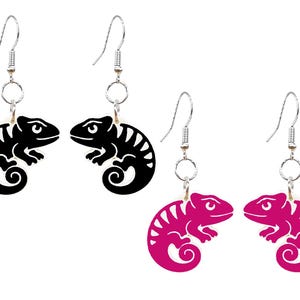 May include: Chameleon-shaped earrings in black and magenta. The earrings feature a detailed cutout design of a chameleon with a curled tail and are suspended from silver-colored hooks. The earrings are a fun and unique accessory.