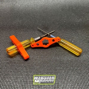 May include: A set of three orange and yellow plastic screwdrivers with a star-shaped bit. The screwdrivers are designed for working on small electronics. The set includes a T-shaped screwdriver, a straight screwdriver, and a screwdriver with a star-shaped bit.